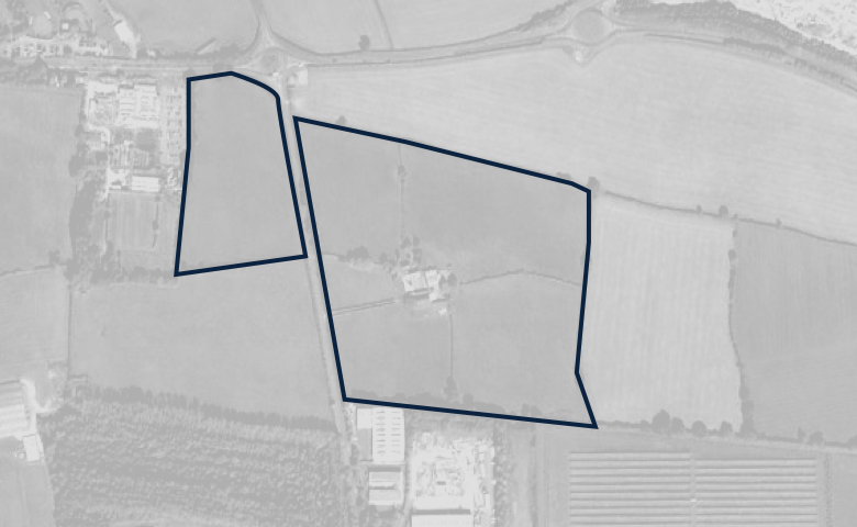 Greyscale aerial image of a plot of land, outlined in dark blue.